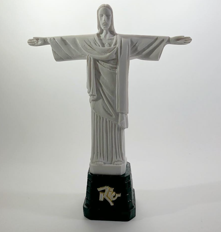 Estátua do Cristo Redentor em resina branca com base escura escrita Rio